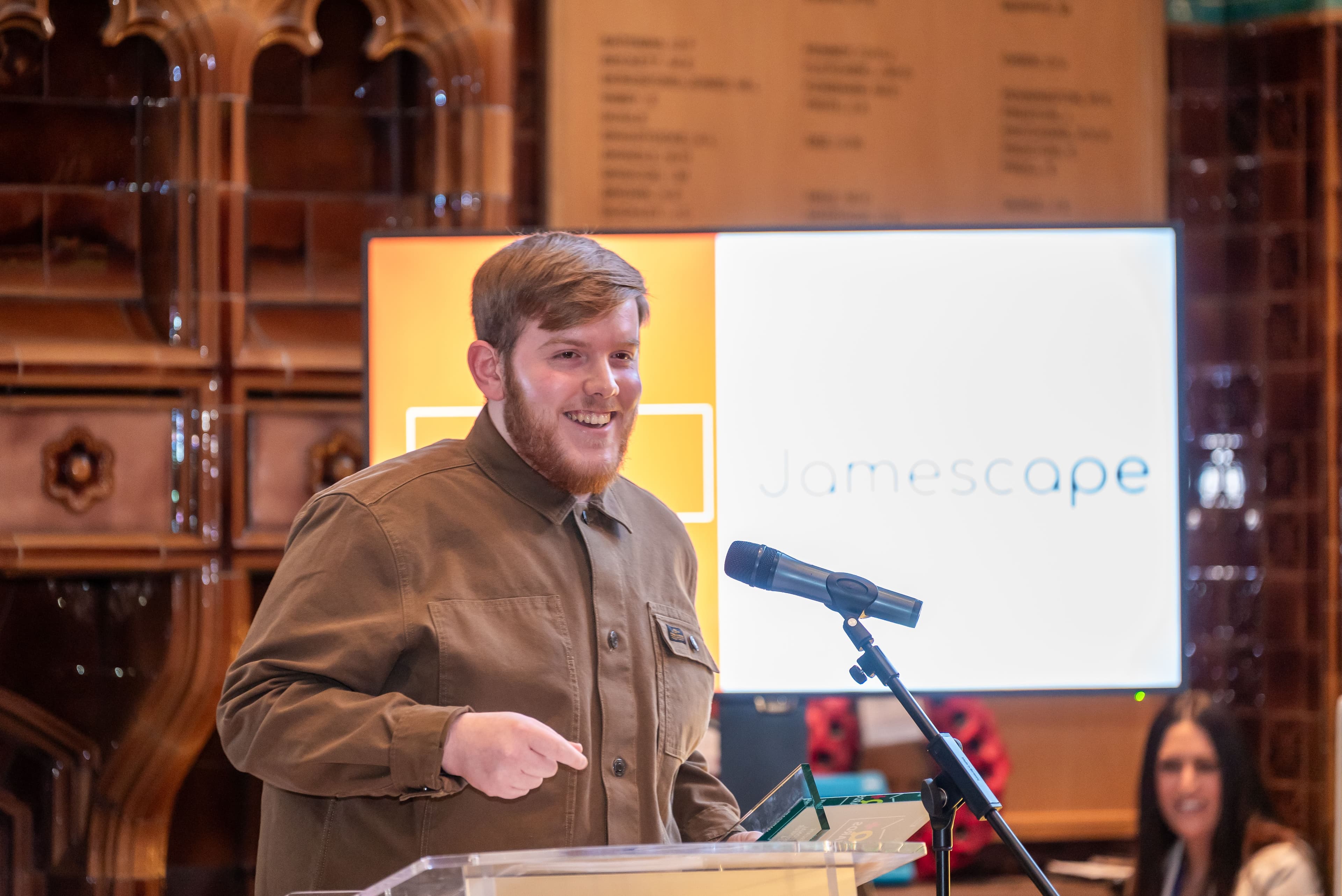 Zack Walker (Chief Operating Officer) speaking at a podium at the front of the Equality+ Awards 2024.